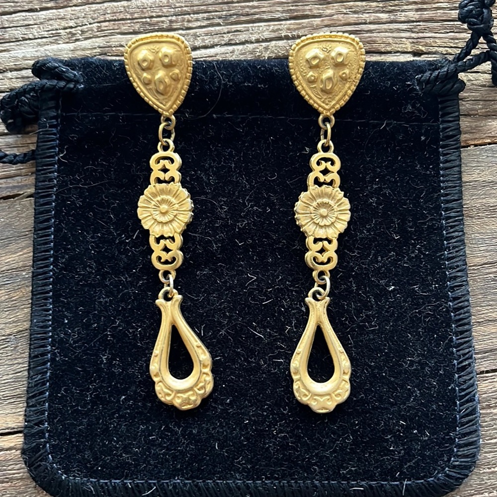 Dangling gold looking pierced earrings.